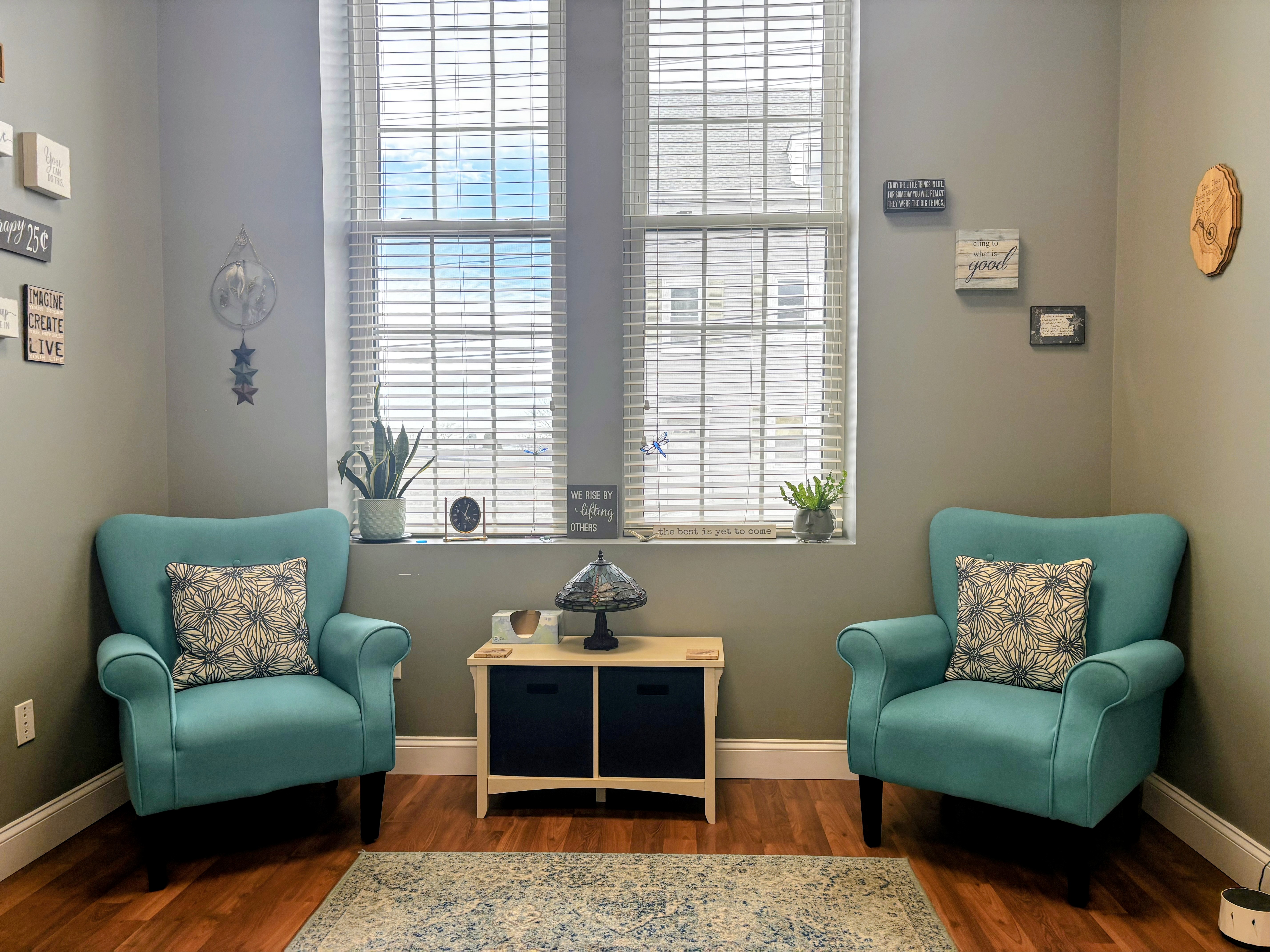 Therapy office with comfortable teal chairs, natural light, and a warm welcoming space